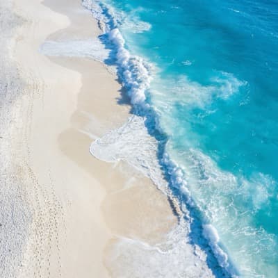 Aerial view of turquoise ocean and white sand